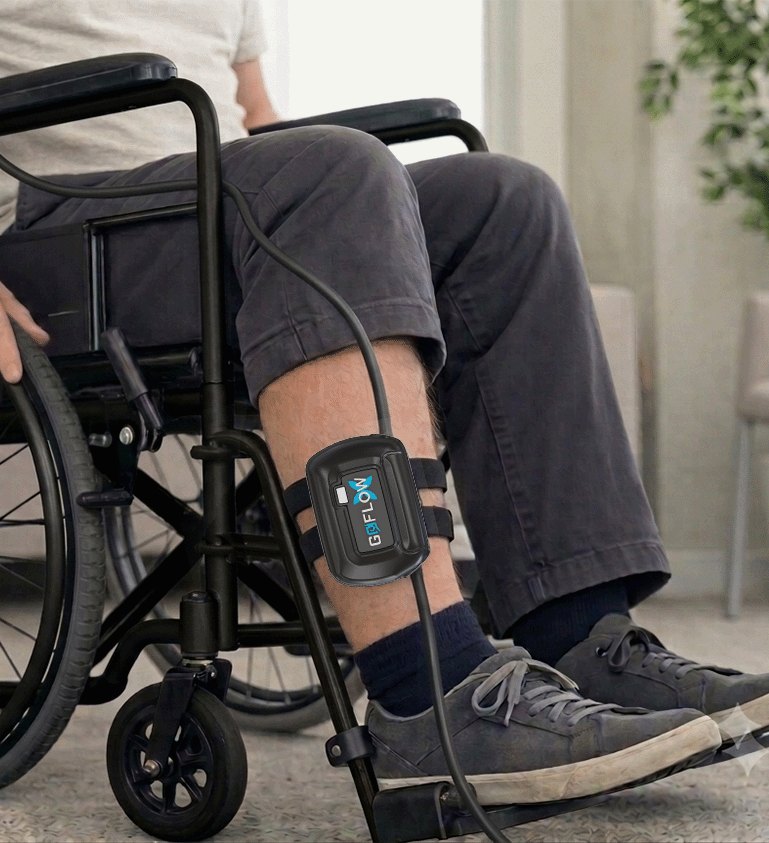 Wheelchair user at home wearing the GoFlowX device strapped to their lower leg
